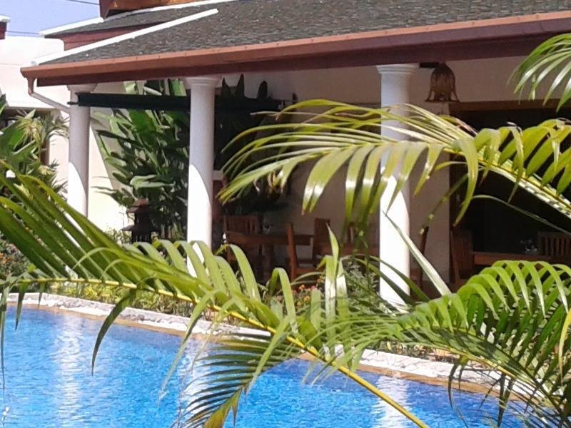 Pool beside a shaded terrace and tropical planting at Baan Malinee