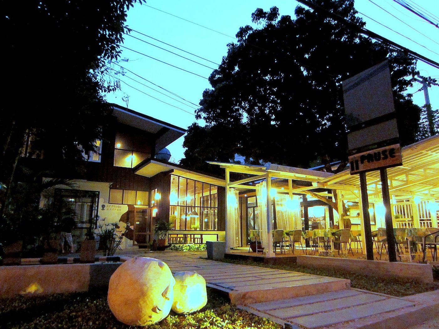 Chiang Mai D Hostel exterior and covered seating at dusk