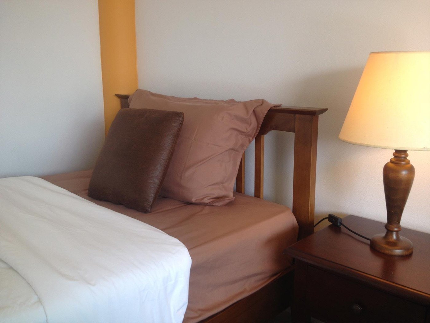 Bed and bedside lamp at Coconut Homes Khao Lak
