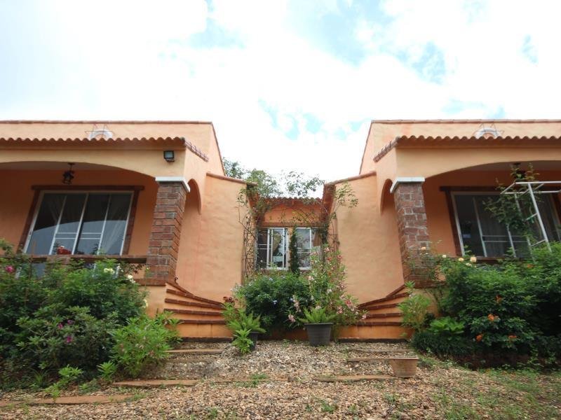 Peach-coloured cottages with entrance steps at Flora Hill Pongyang Resort