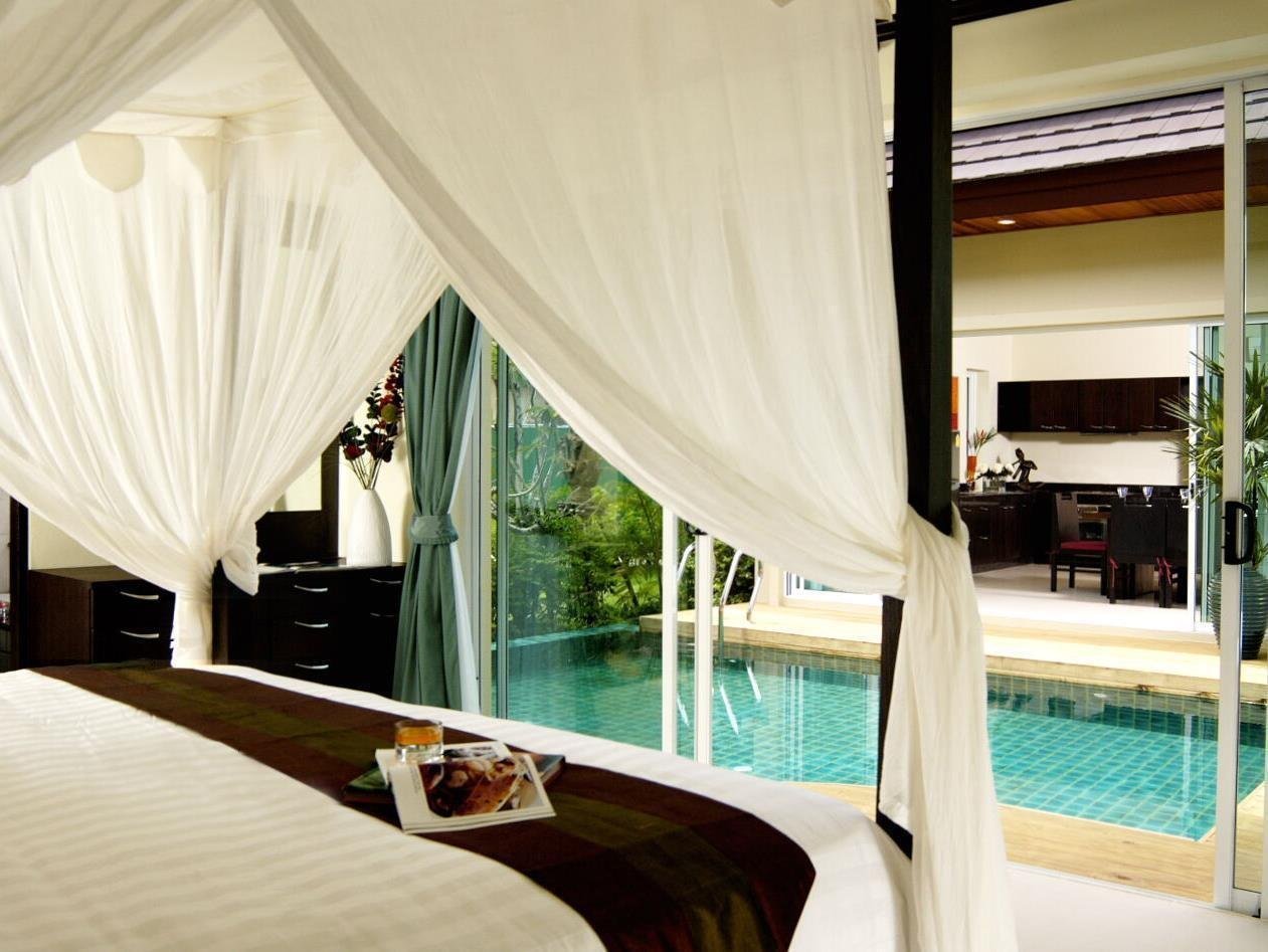 Canopied double bed overlooking a pool at Karon Beach Walk Villa