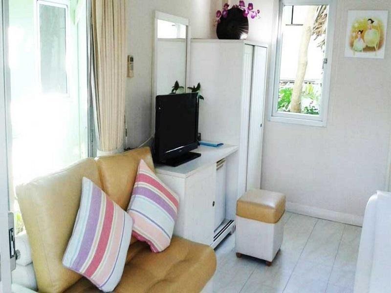 Small sitting area with a sofa, refrigerator and television at Sea Sky Resort