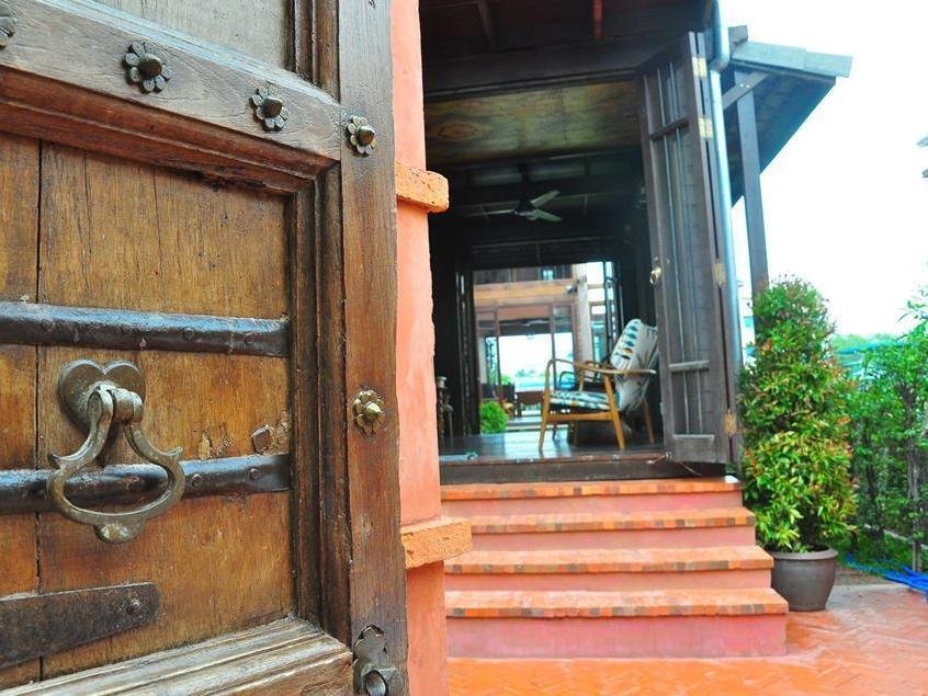 Open wooden entrance and steps leading into Siamotif Boutique Hotel