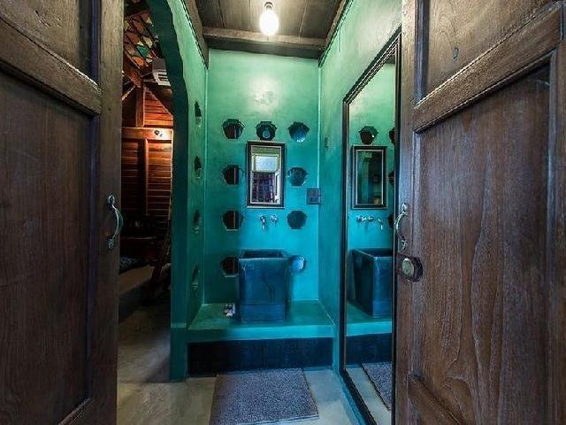 Turquoise bathroom framed by wooden doors at Siamotif Boutique Hotel