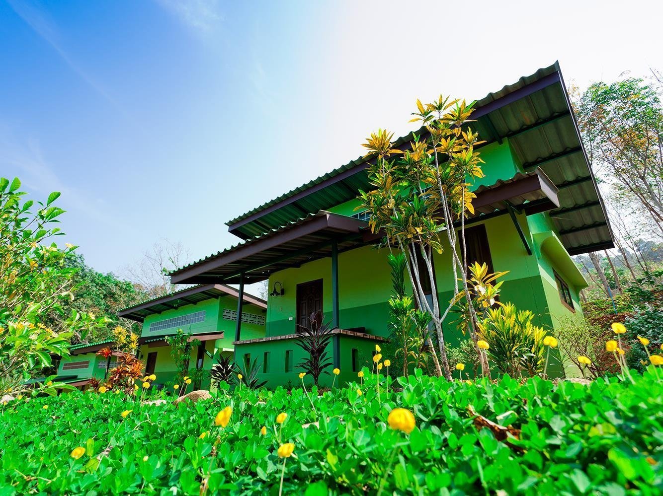Green bungalow surrounded by flowers at The Mouth Resort